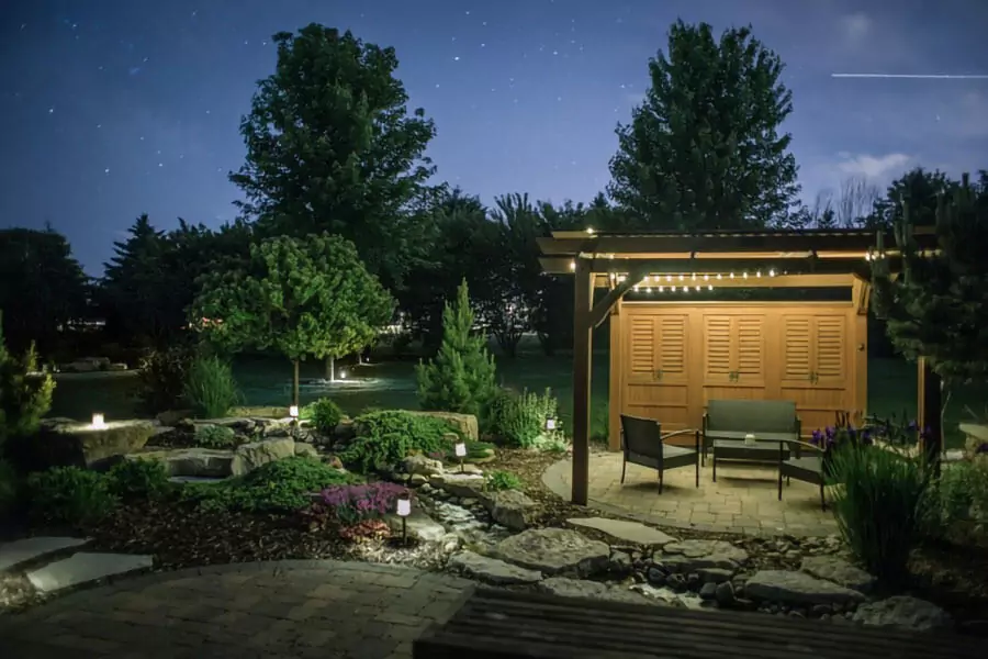 landscape lighting install on a patio and there has three chairs and a table