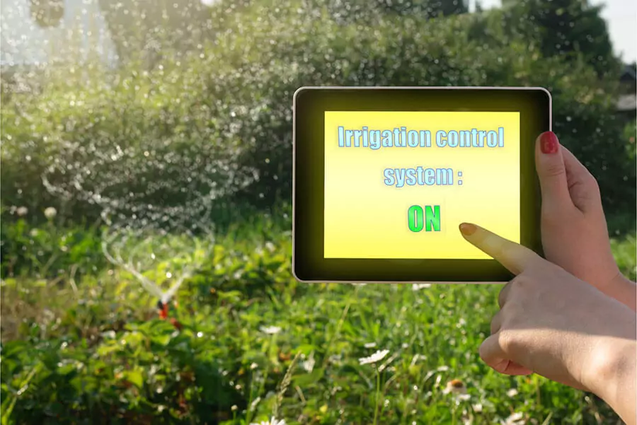 hands are controlling irrigation system by tablet with green background