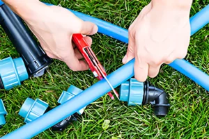 Sprinkler system contractor repairing pipe