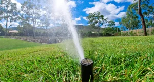 Sprinkler system operating on residential lawn in Humble TX to prevent water pooling and improve irrigation efficiency