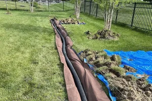 French drain installation in progress in Humble, TX backyard, part of professional drainage solutions to prevent standing water and foundation damage.